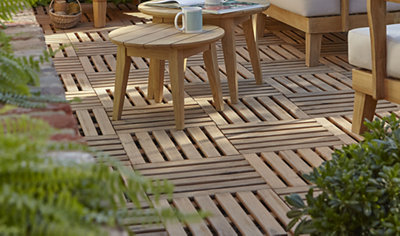 A decked garden area featuring square slatted timber decking tiles, creating a clean and modern outdoor space.