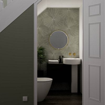Cloakroom bathroom beneath a staircase with a round mirror above the vanity.