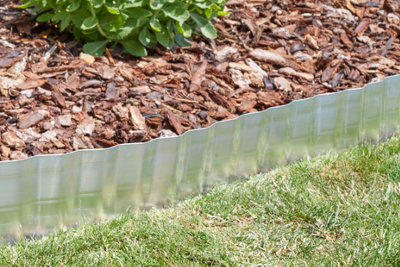 Steel garden edging diving grass and bark.