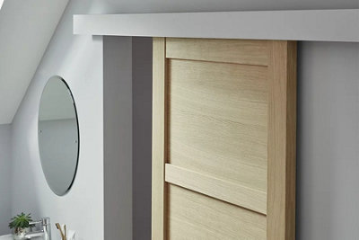 Wooden sliding door in a grey cloakroom.