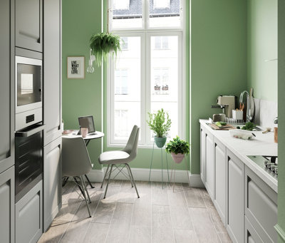 Green galley kitchen with light grey cabinetry and light grey laminate flooring.