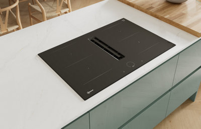 Gloss slab kitchen doors with integrated handles, shown in a light and modern space featuring a white marble-effect worktop and induction hob on an island.