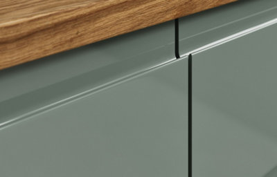 A close up of a gloss slab kitchen doors with integrated handles and dark wooden countertop