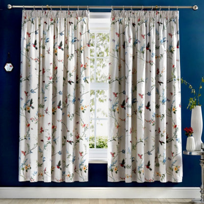 Floral white patterned curtains in a blue living room.