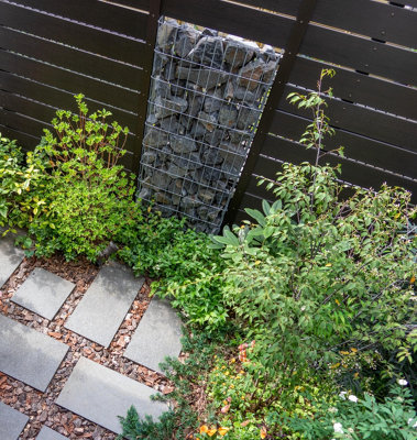 Decorative gabion feature made from steel wire cages filled with stones, adding a stylish and modern touch to the garden.