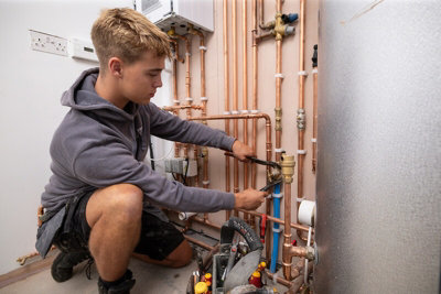 Gen Z tradesperson working on pipework