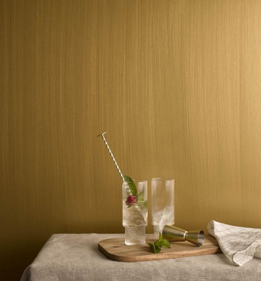 A room with shimmering antique gold effect paint on the walls, creating a luxurious and glamorous atmosphere.
