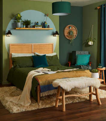 A bedroom with green walls in varying shades, ranging from deep emerald to soft sage, creating a calming and nature-inspired atmosphere.