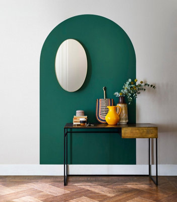 A hallway featuring a stylish green painted arch mural behind a console table.