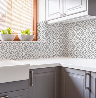 Grey and white tile effect kitchen wallpaper in a kitchen with grey cabinets and white worktops.