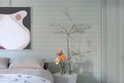Light grey bedroom with horizontal wooden wall panels painted in grey.