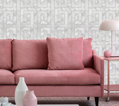 Grey living room with white and grey geometric wallpaper and a blush pink sofa.