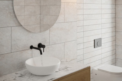 Modern bathroom with grey tiles and dark grey grout.