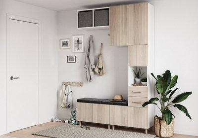 White hallway featuring a modular Atomia storage unit with white frames and light wood doors, complete with a built-in bench and wall hooks for coats.