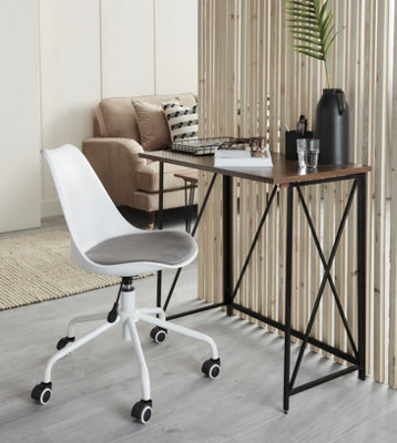 A home office in a living room separated by a room divider made from thin vertical wooden panels.