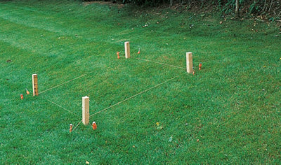 A square marked out on a sloping patch of lawn using a builder's line and pegs.