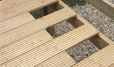 A garden deck with deck boards removed at the edge, exposing the supporting framework underneath.