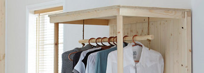 Timber home made wardrobe with a clothes rail hanging from a piece of rope and an open front.