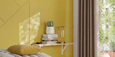 A yellow bedroom wall with thin timber strips mounted at various angles to create a modern look.