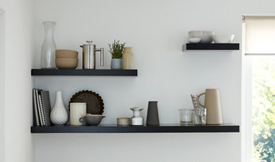 Three different sized floating shelves installed on a wall without any visible brackets.