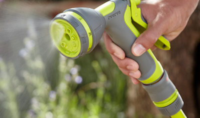 Close up of a garden hose spraying water on a mist setting.