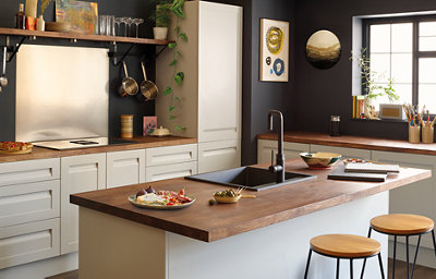 The Garcinia kitchen, featuring light grey cabinets with integrated handles, and countertops with a stained wood finish.