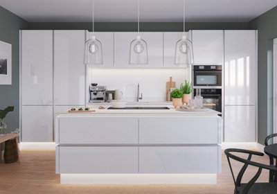 Large kitchen with white handleless gloss cabinets with plinth lighting, under cabinet lights, and statement pendant lights.