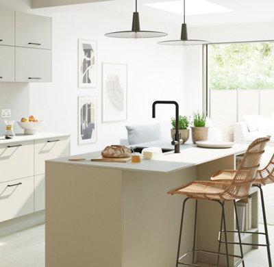 Large Scandi-style kitchen with cream matt cabinets, black accents, and rattan bar stools.