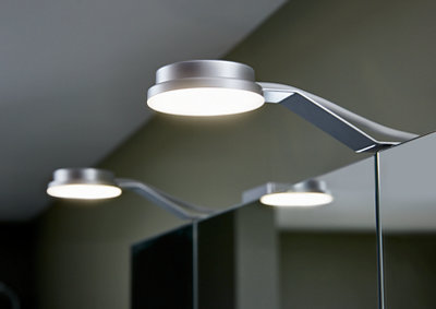 Two small light fixtures attached to the top of a bathroom mirror.