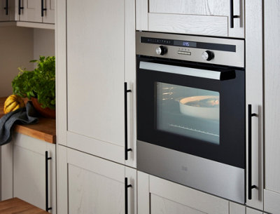 A light grey kitchen with a compact kitchen oven.