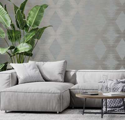 Light grey living room with grey and metallic diamond pattern geometric wallpaper, a light grey corner sofa, and a large bird of paradise houseplant.