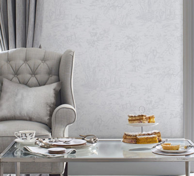 Light grey living room with grey Laura Ashley wallpaper, grey armchair, grey curtains, and a glass coffee table.