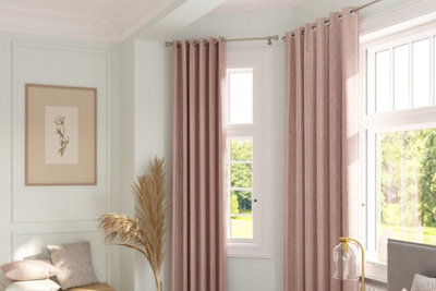 Living room space with light green painted walls and pink curtains.