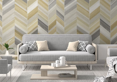 Living room decorated with yellow and grey geometric striped wallpaper, light grey sofa, and light wooden accents.
