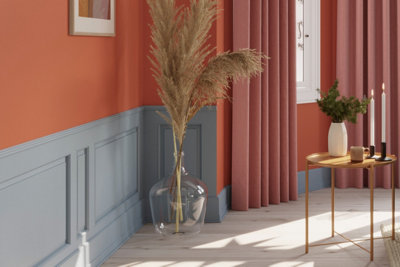 Orange and blue living room with light blue panelling on lower half of walls, and rest of the walls are painted in orange paint.