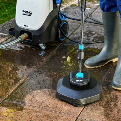 Person using a Mac Allister M4 corded pressure washer to clean outdoor paving