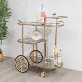 Melody Maison Large Gold Antique Glass Oval Drinks Trolley With Wheels