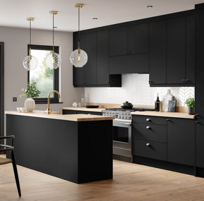 Modern black kitchen cabinets with white walls, light wooden worktops, and light wooden flooring.