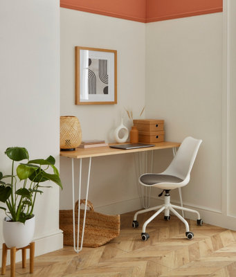 An office space with white walls and wooden flooring, with a wooden desk and white office chair in an alcove.