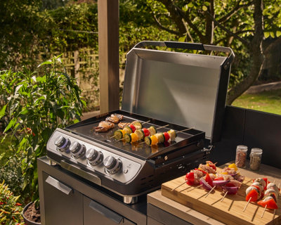 Skewers cooking on an Adriano 4 burner tabletop gas plancha in black & stainless steel
