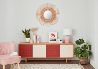 A room featuring a pink chair, a red and white furniture unit, and walls painted with light grey eggshell paint.