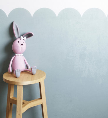 A blue wall featuring a playful scallop paint effect, adding soft, organic shapes to a room.