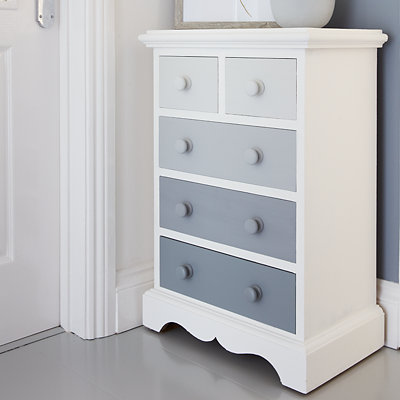 A white chest of drawers with the drawers painted in various shades ofo grey to create an ombre effect. Shop GoodHome interior furniture paint.