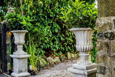 Pair of Large Stone Cast Flute Urns and Classic Plinths