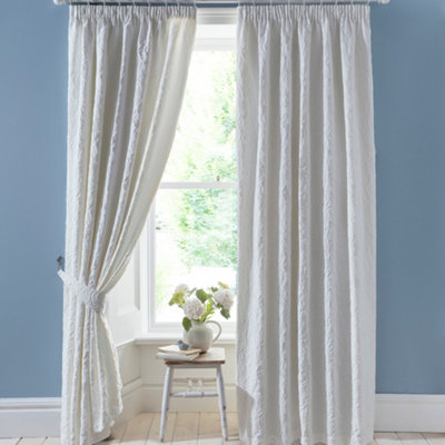 Pair of pencil pleat curtains with tie-backs.