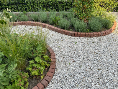 Large curved stone path bordered with brown bricks.