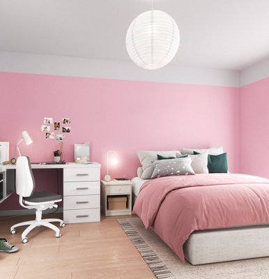 A bedroom with pink walls and a white ceiling with some of the paint extending from the ceiling onto the walls, creating a soft and cosy atmosphere.