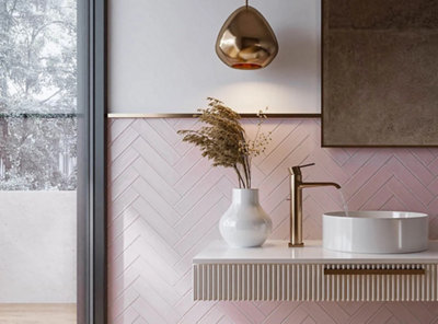 Pink bathroom tiled splashback behind a floating basin unit, the rest of the wall is painted white.