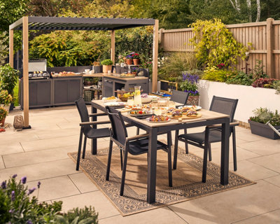 GoodHome Cucino Powder-coated Grey Steel Wood effect Outdoor kitchen beneath a pergola.