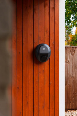 Pod charger installed on a timber panelled wall.